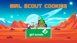 Girl scout cookie page. Picture of the martian landscape with Snarky sitting at a table with a Girl Scout banner and boxes of cookies for sale